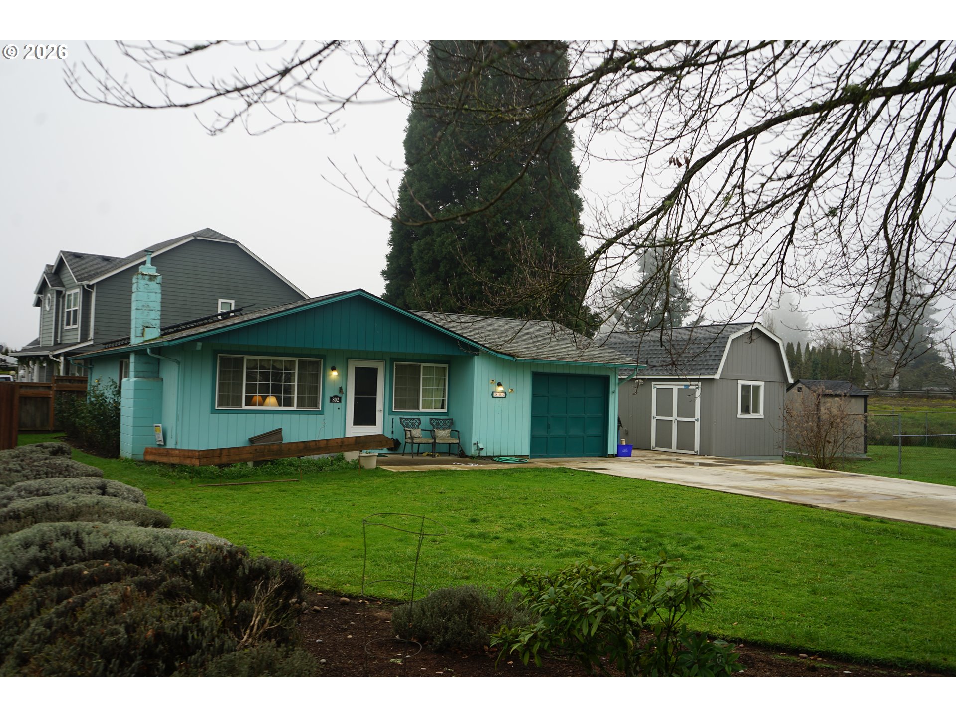a front view of a house with a yard and trees