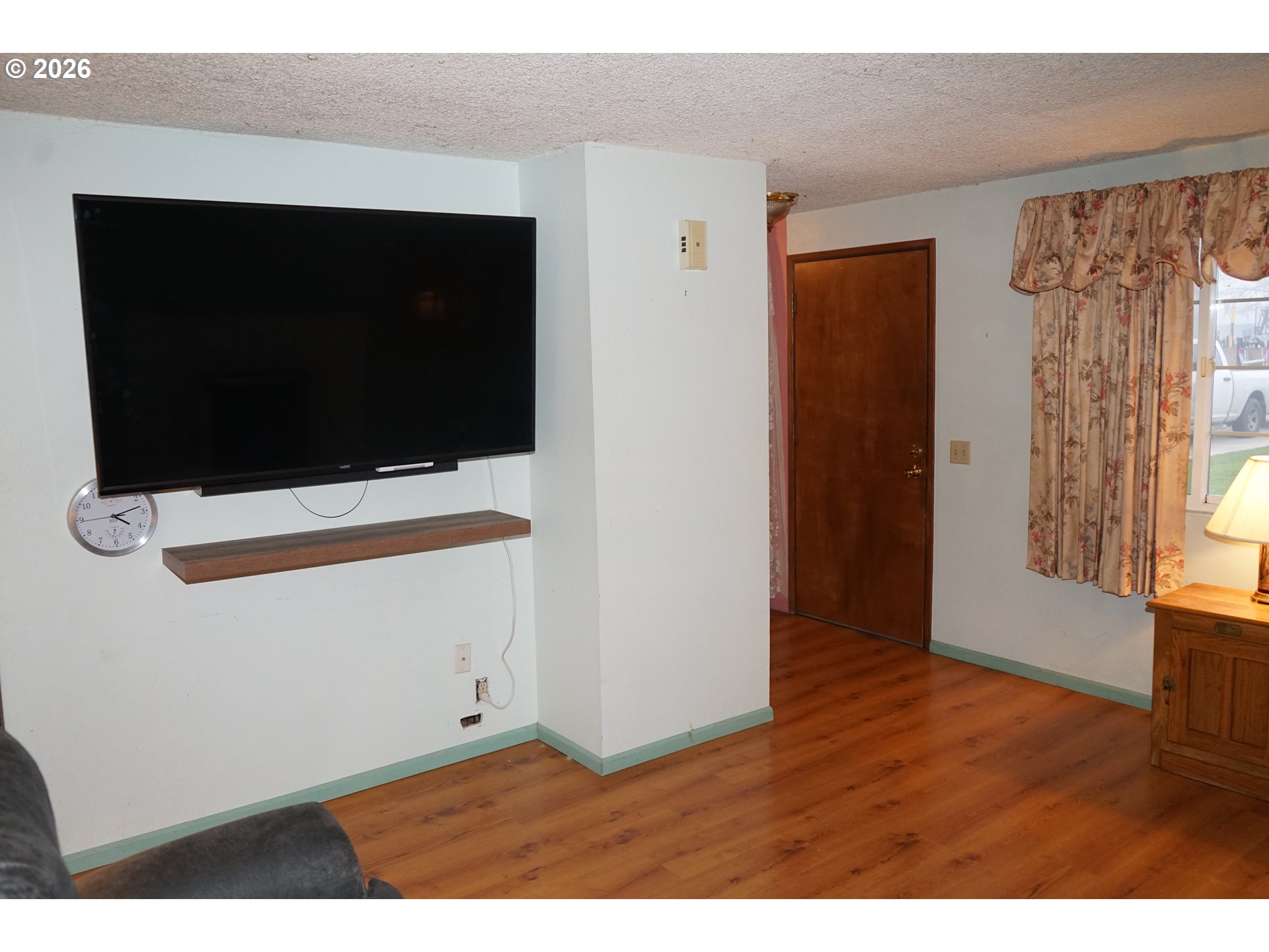 802 54th Place Springfield, OR 97478 - Photo 3 of 27 a view of an empty room with wooden floor and a flat screen tv