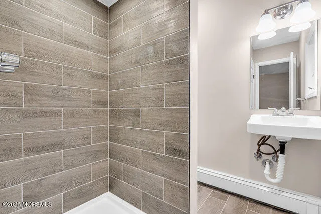 a bathroom with a sink a shower and a mirror