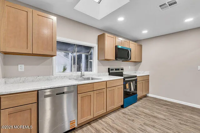 a kitchen with stainless steel appliances granite countertop a sink stove and microwave