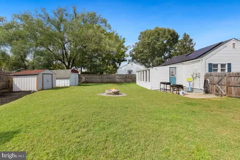 a view of a house with a backyard and a tree