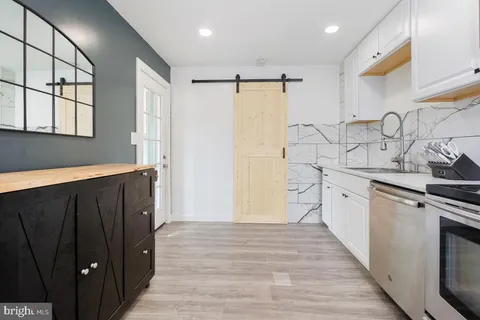 a kitchen with granite countertop white cabinets and white appliances