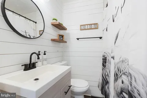 a bathroom with a sink a toilet and a mirror