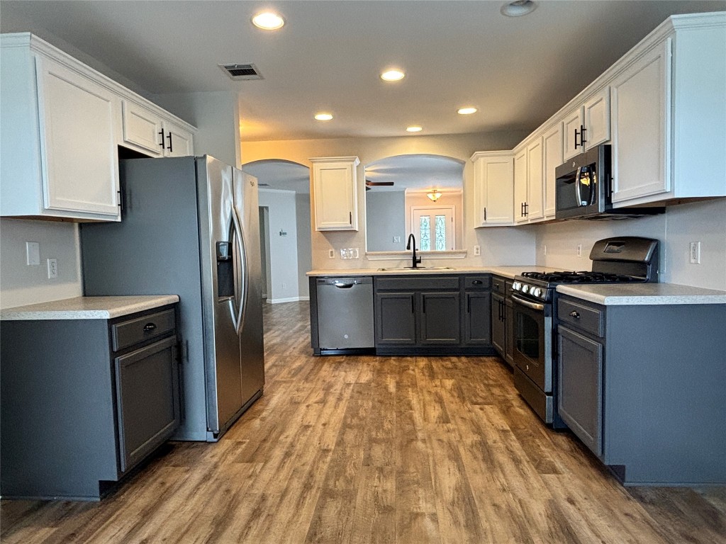1702 McDowell Bend Leander, TX 78641 - Photo 3 of 13 a large kitchen with stainless steel appliances granite countertop a stove cabinets and wooden floor