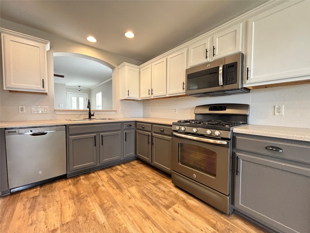 1702 McDowell Bend Leander, TX 78641 - Photo 4 of 13 a kitchen with stainless steel appliances granite countertop a sink dishwasher a stove and a microwave oven with cabinets