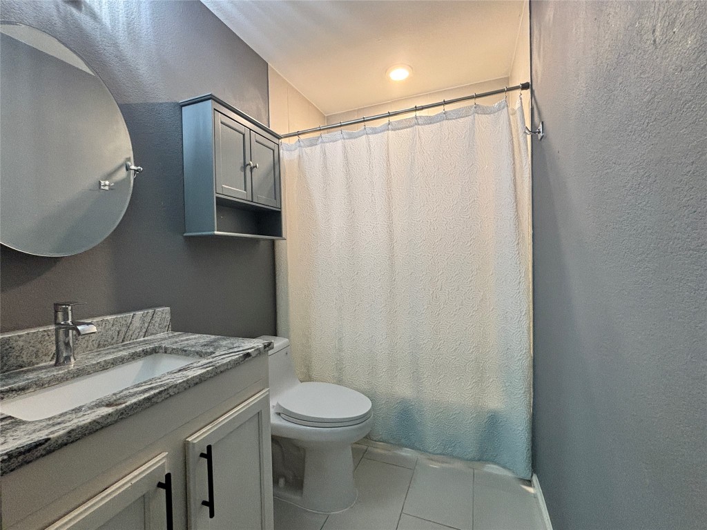 1702 McDowell Bend Leander, TX 78641 - Photo 9 of 13 a bathroom with a granite countertop sink toilet and shower