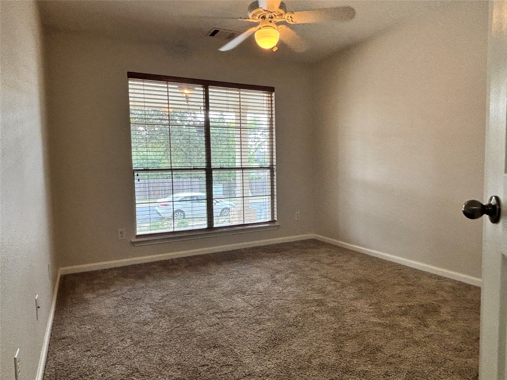 1702 McDowell Bend Leander, TX 78641 - Photo 10 of 13 an empty room with windows and chandelier fan