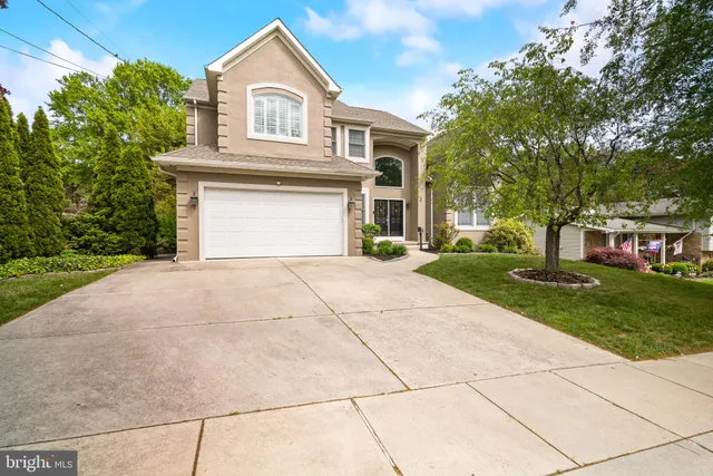 a front view of a house with a yard and trees