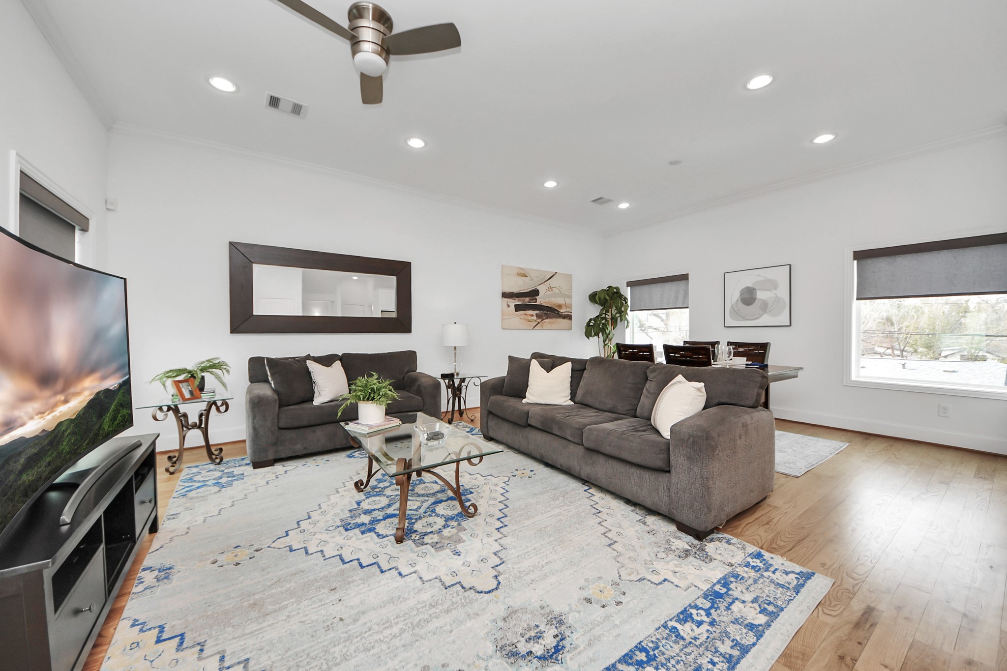 1628 West 24th Street Houston, TX 77008 - Photo 7 of 41 Experience airy elegance with high ceilings and abundant natural light streaming through expansive picture windows, complete with convenient electronic shades.