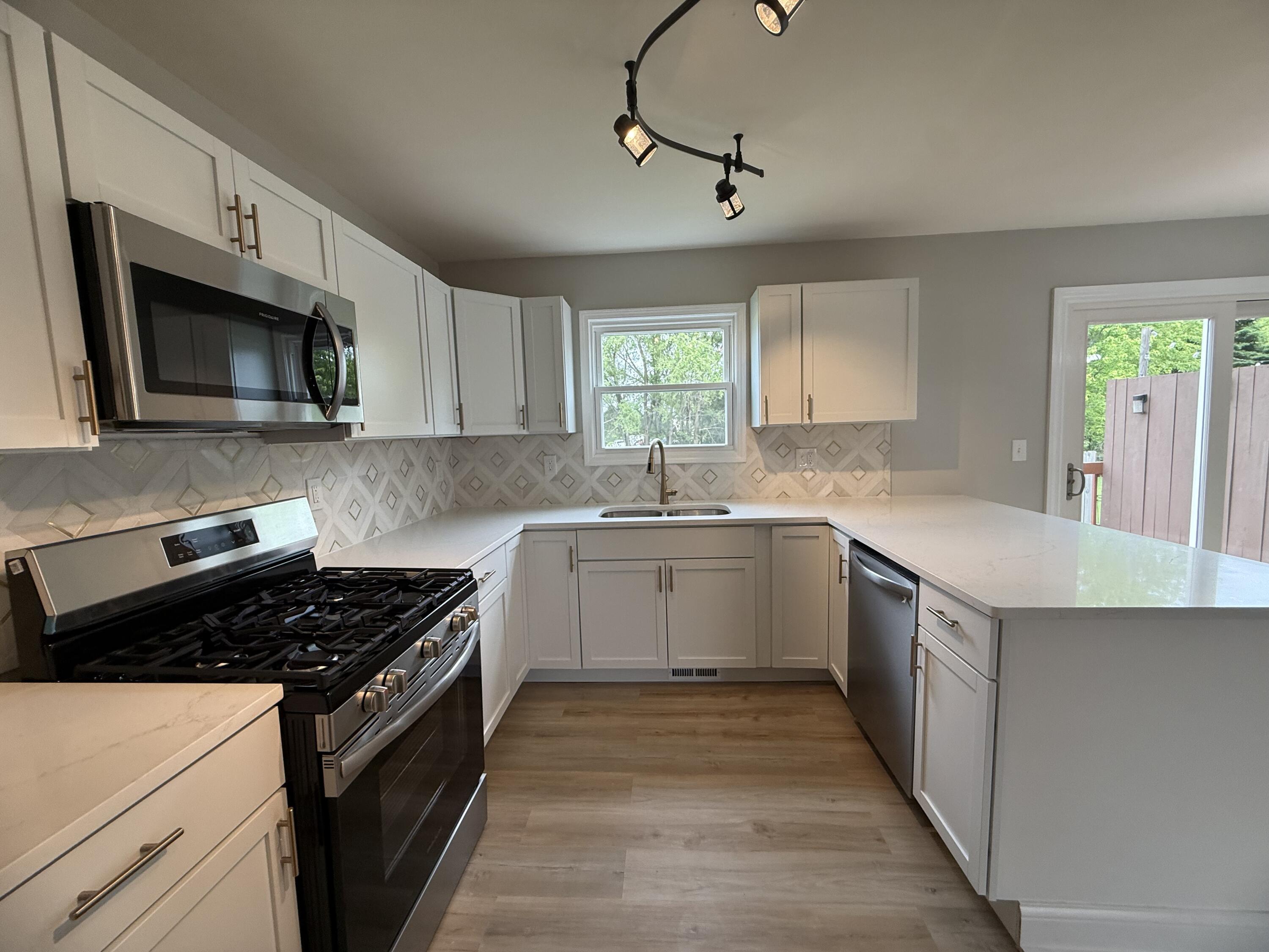 15895 Sherman Street Lowell, IN 46356 - Photo 13 of 36 a kitchen with a sink stove and microwave