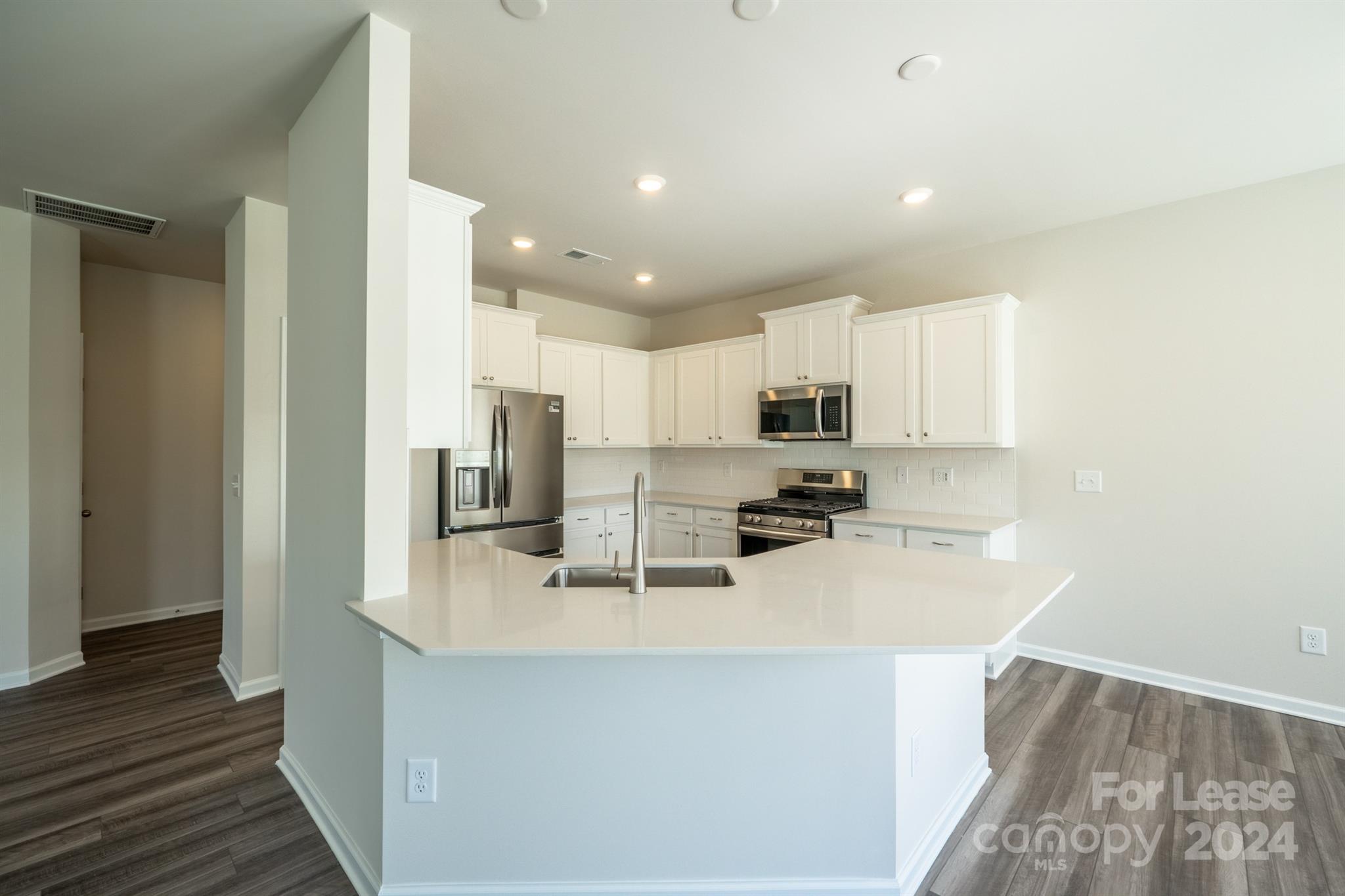 15307 Lake Ridge Road Charlotte, NC 28278 - Photo 13 of 33 a kitchen with kitchen island a sink stainless steel appliances and cabinets