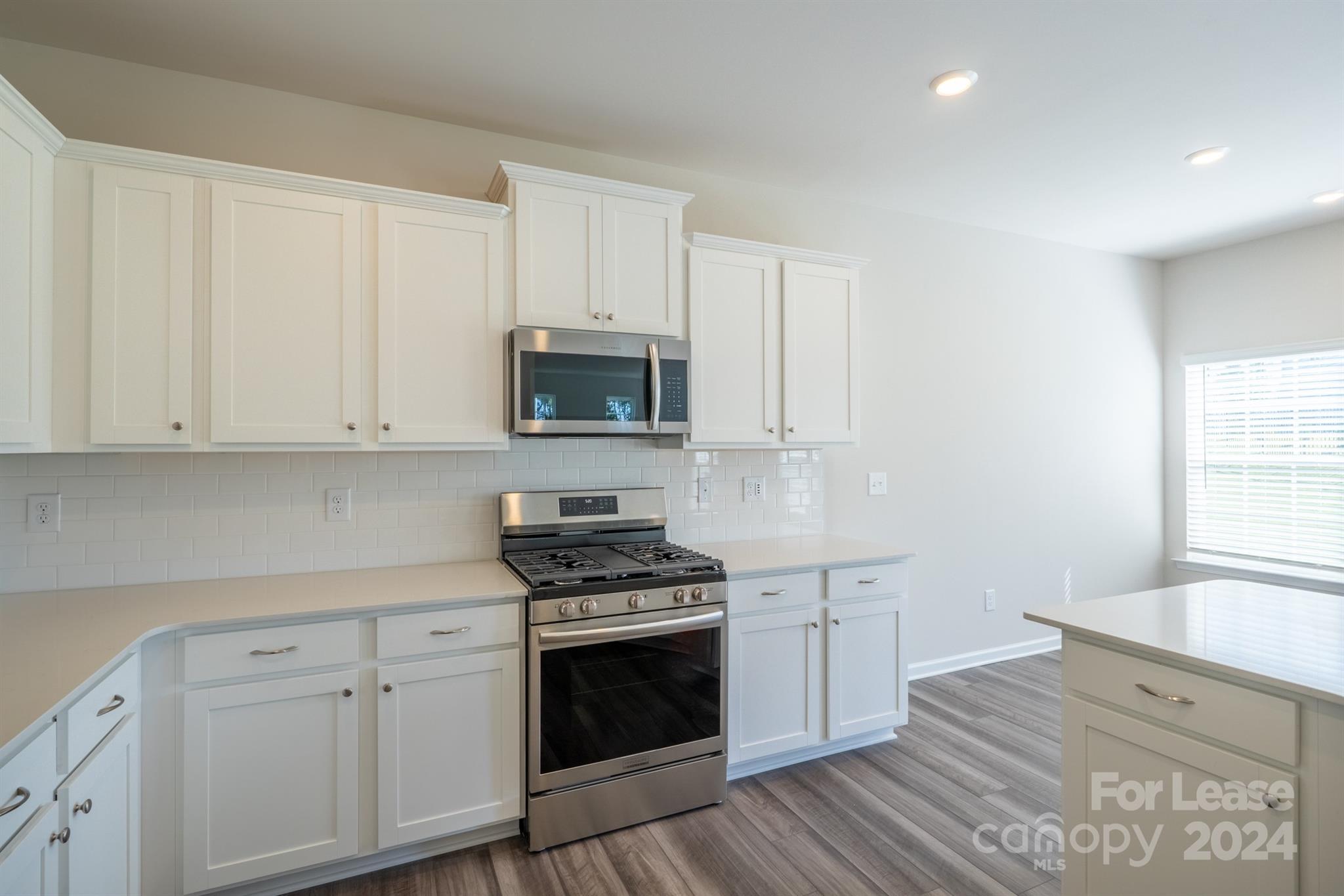 15307 Lake Ridge Road Charlotte, NC 28278 - Photo 14 of 33 a kitchen with white cabinets and appliances