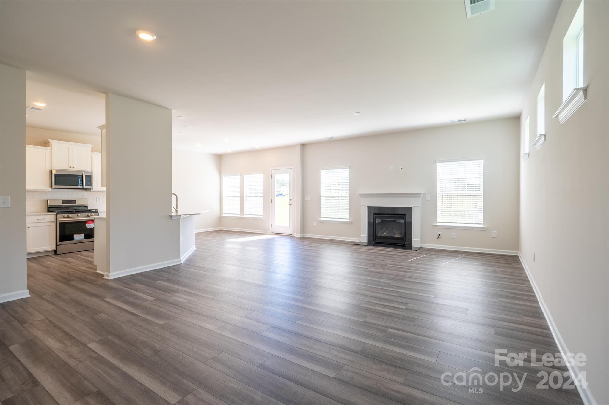 15307 Lake Ridge Road Charlotte, NC 28278 - Photo 4 of 33 an empty room with wooden floor and fireplace
