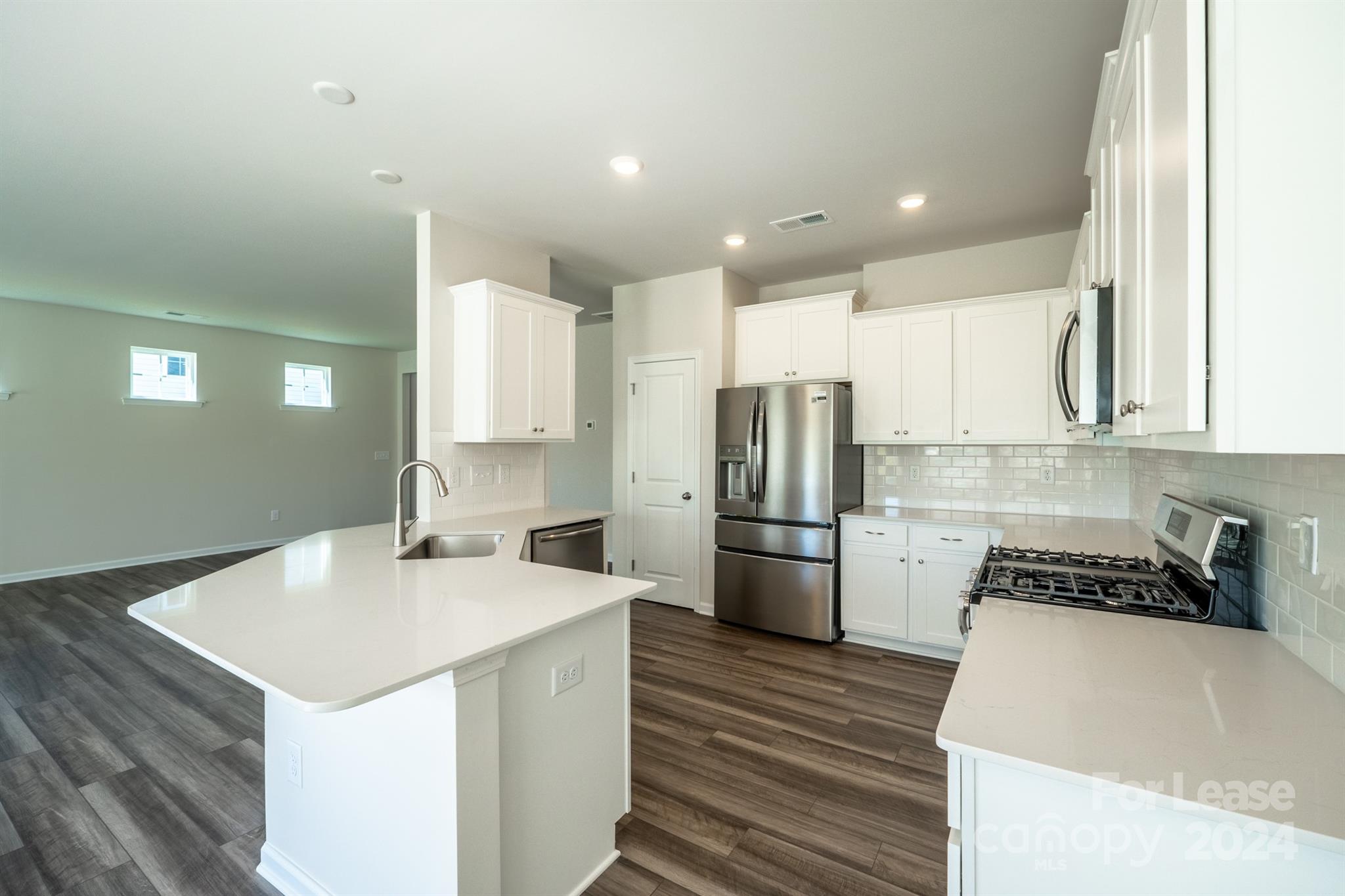 15307 Lake Ridge Road Charlotte, NC 28278 - Photo 9 of 33 a kitchen that has a sink a refrigerator and a stove top oven
