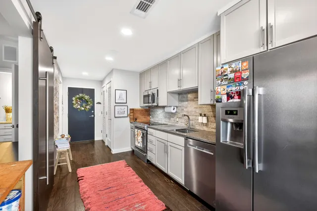a kitchen with stainless steel appliances granite countertop a sink and cabinets