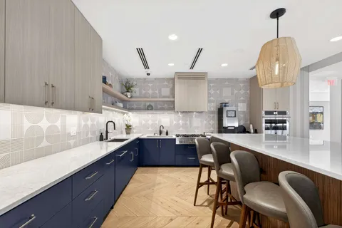 a kitchen with stainless steel appliances kitchen island granite countertop a stove a sink and a microwave