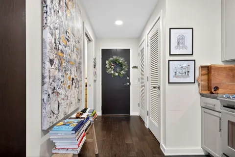 a view of a hallway with wooden floor and staircase