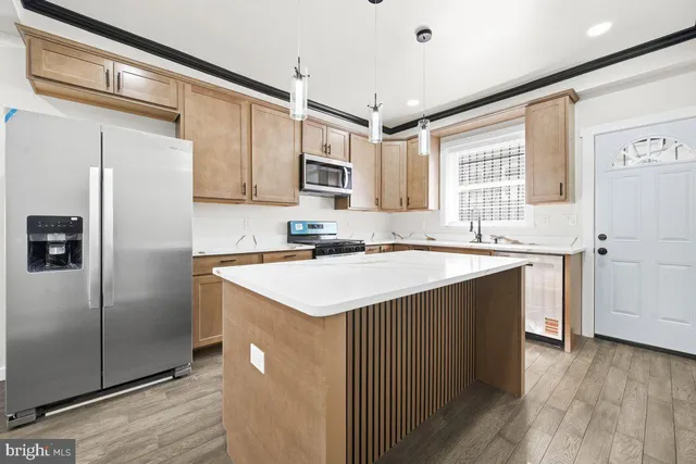 a kitchen with a sink a refrigerator a window and cabinets