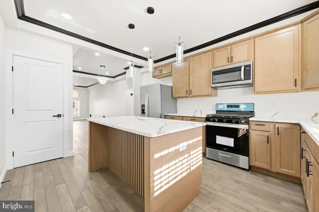 a kitchen with stainless steel appliances granite countertop a stove and a refrigerator