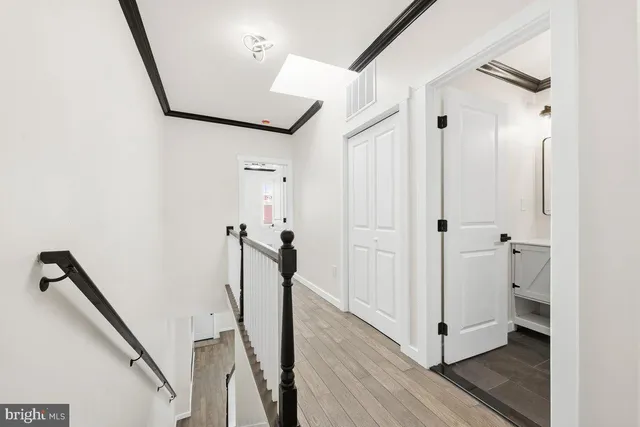 a view of a hallway with a white walls and stairs
