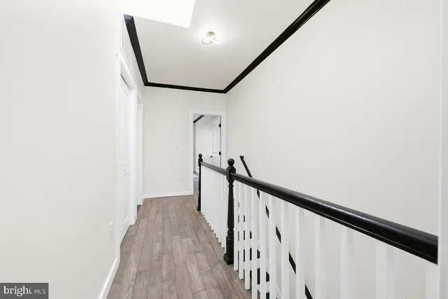 a view of a hallway with wooden floor and staircase