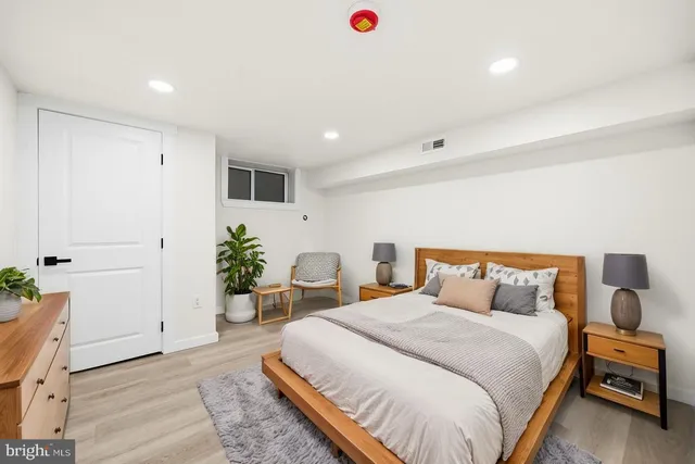 a bedroom with a large bed and a potted plant