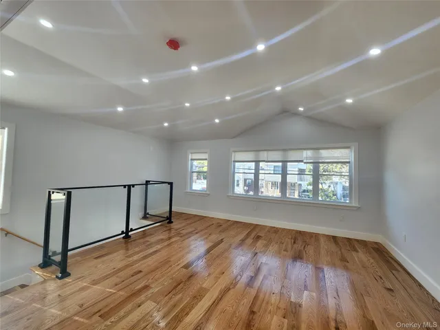 a view of empty room with wooden floor and fireplace