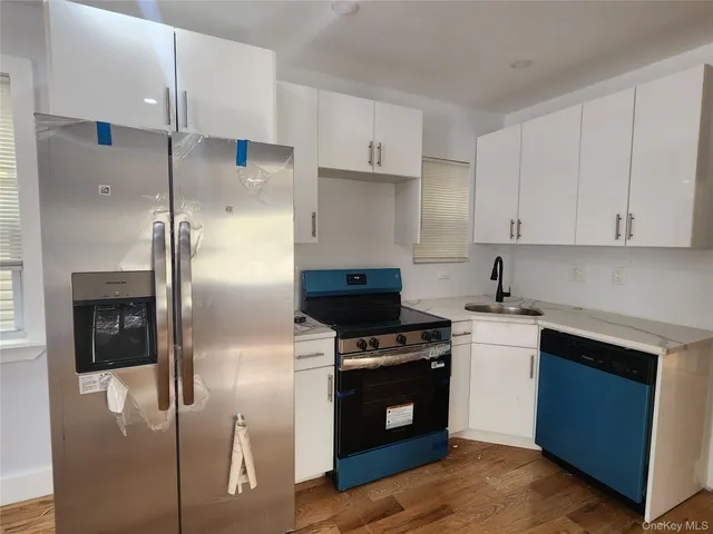 a kitchen with a sink and wooden floor