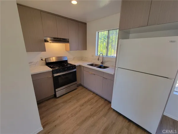 a kitchen with a refrigerator a stove a sink a microwave and cabinets
