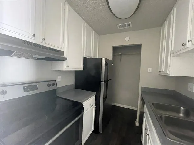 a kitchen with stainless steel appliances granite countertop a sink refrigerator and cabinets