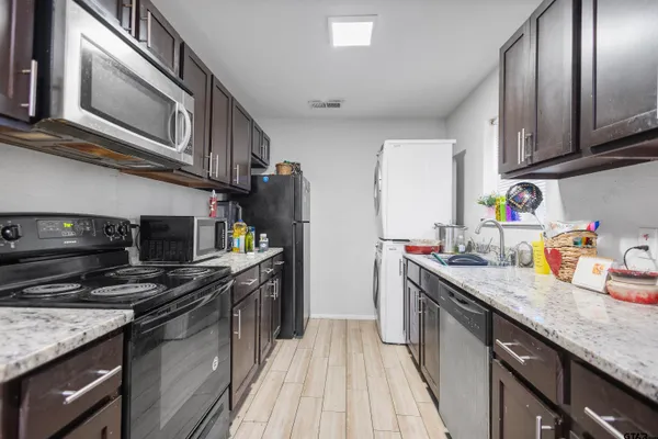 a kitchen with stainless steel appliances granite countertop a sink stove and refrigerator
