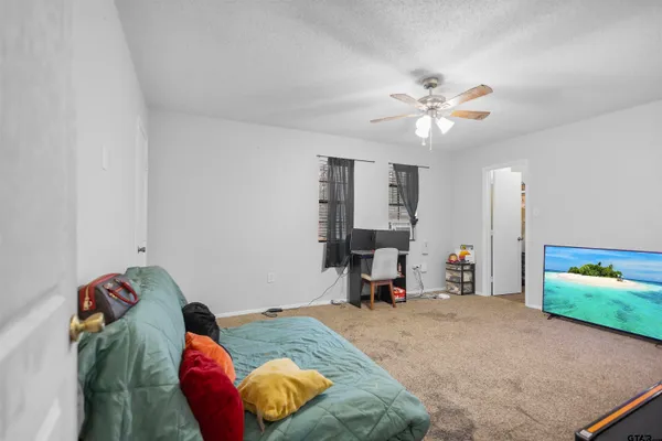 a bedroom with bed and a chandelier fan