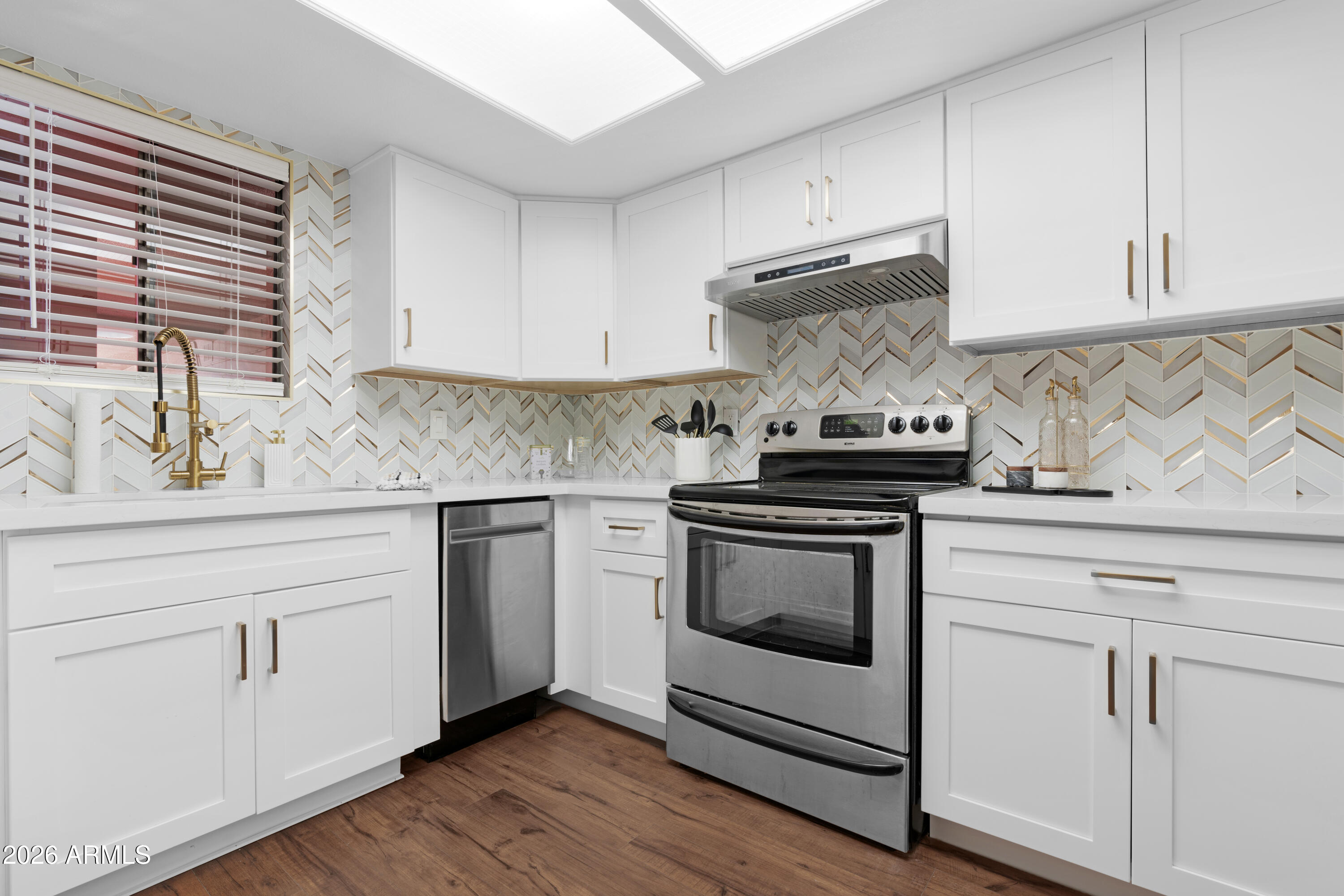 4303 East Cactus Road, Unit 410 Phoenix, AZ 85032 - Photo 11 of 50 a kitchen with white cabinets and appliances