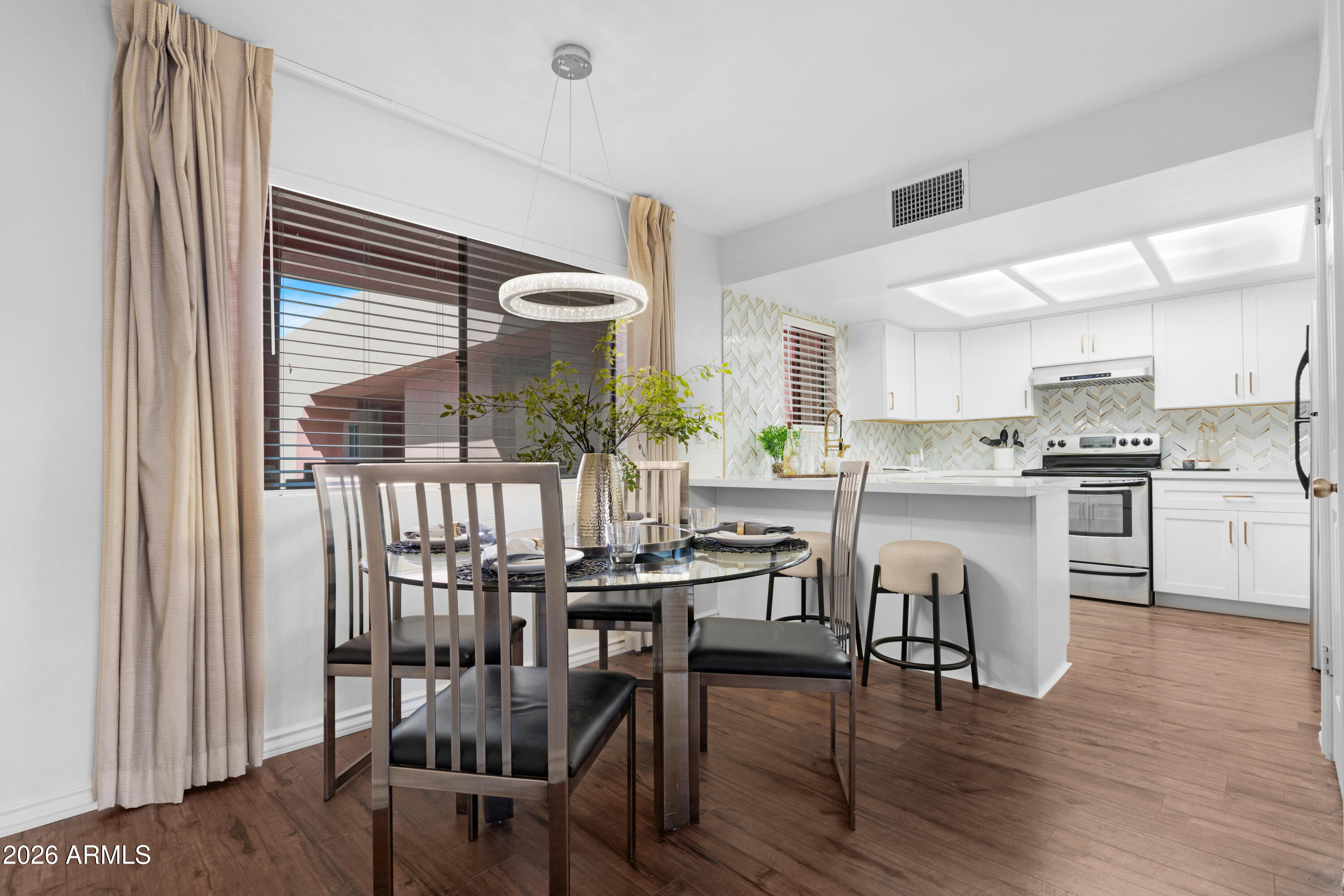 4303 East Cactus Road, Unit 410 Phoenix, AZ 85032 - Photo 18 of 50 a kitchen with a table chairs refrigerator and cabinets