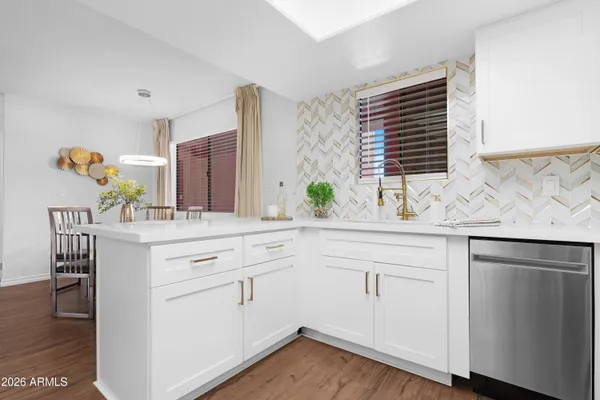 a kitchen with white cabinets and sink