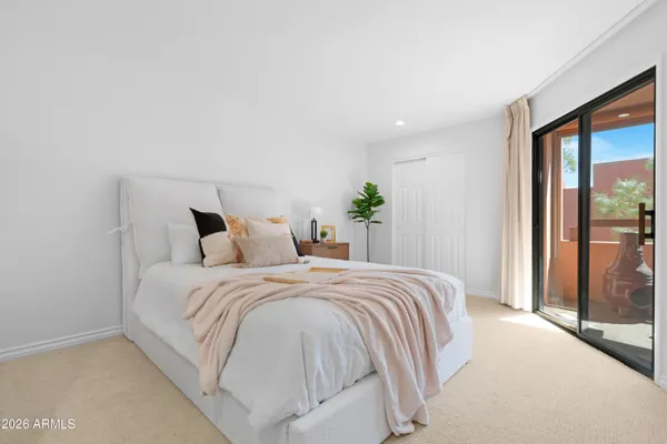 a bedroom with a large bed and a large mirror next to a window