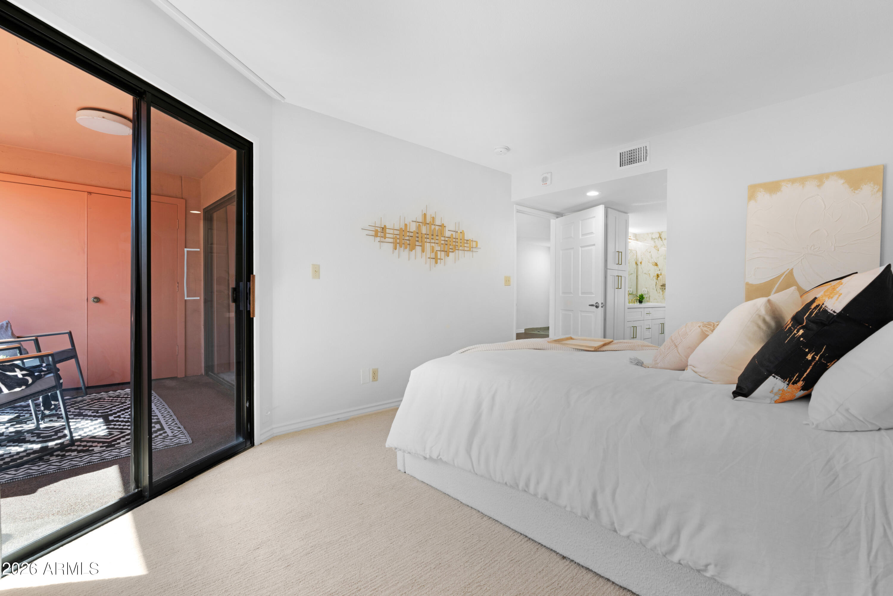 4303 East Cactus Road, Unit 410 Phoenix, AZ 85032 - Photo 28 of 50 a bedroom with a large bed and a large mirror next to a window