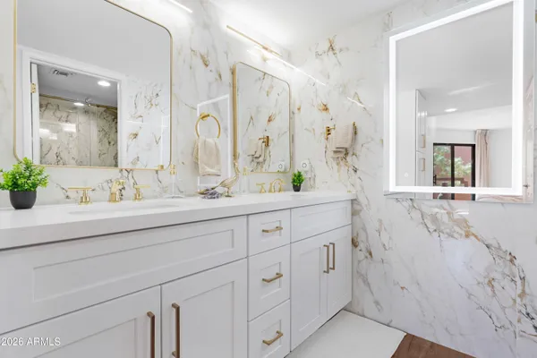 a bathroom with a double vanity sink mirror and shower