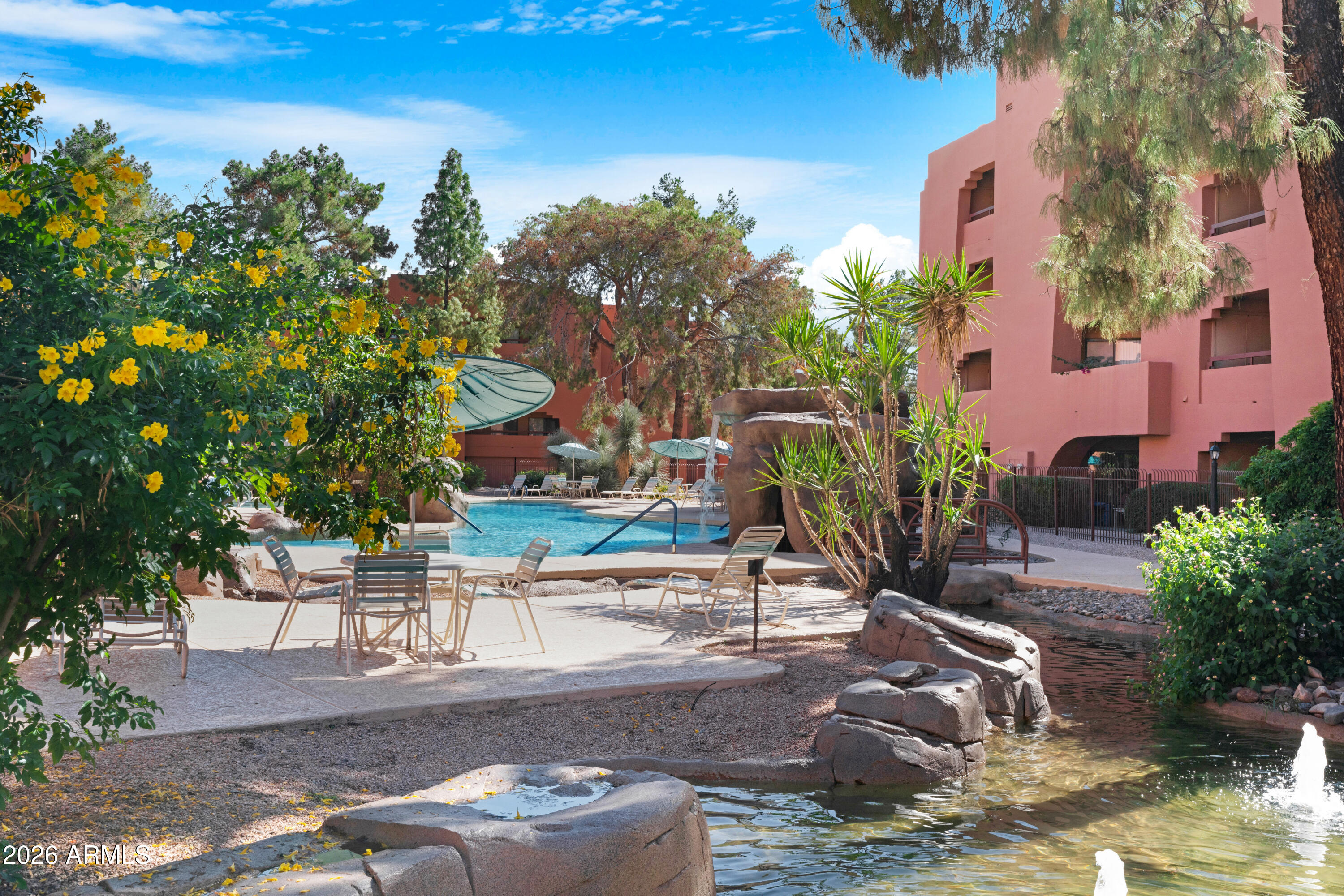 4303 East Cactus Road, Unit 410 Phoenix, AZ 85032 - Photo 48 of 50 a backyard of a house with table and chairs