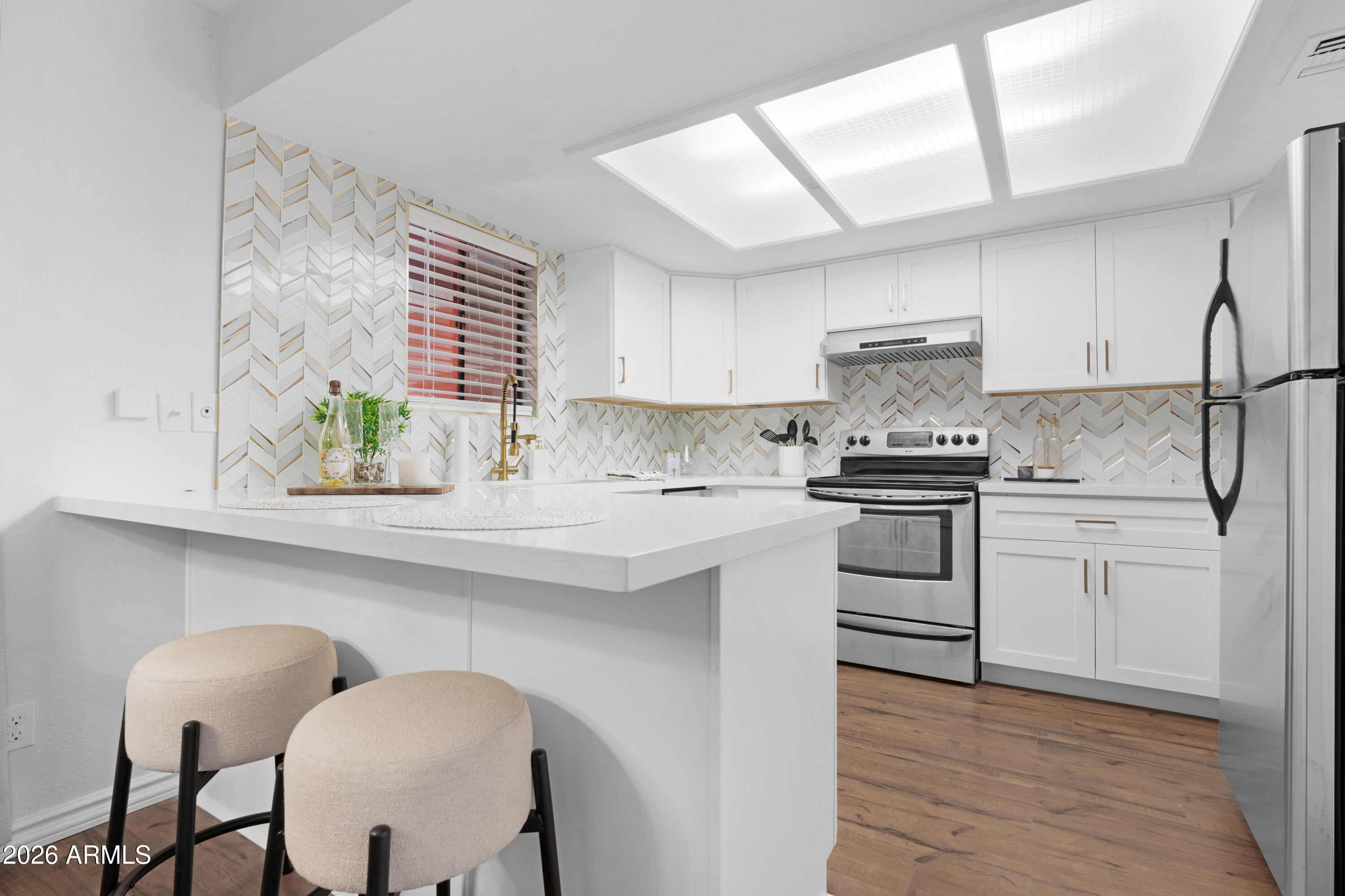 4303 East Cactus Road, Unit 410 Phoenix, AZ 85032 - Photo 8 of 50 a kitchen with white cabinets and appliances