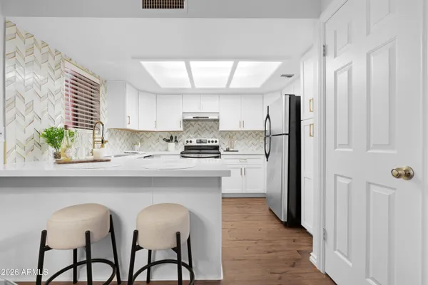 a kitchen with granite countertop a refrigerator and a stove top oven