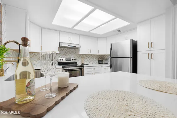a kitchen with white cabinets and appliances