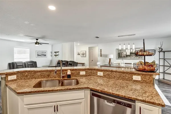 a kitchen with stainless steel appliances granite countertop a sink stove and cabinets