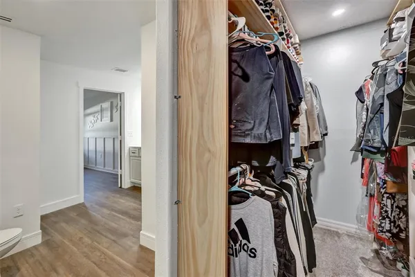a view of walk in closet with clothes