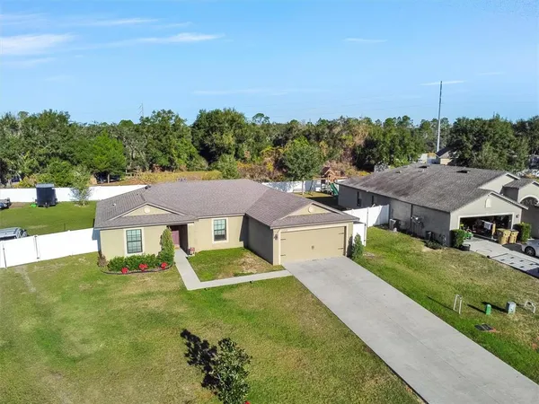 an aerial view of residential houses with outdoor space and trees
