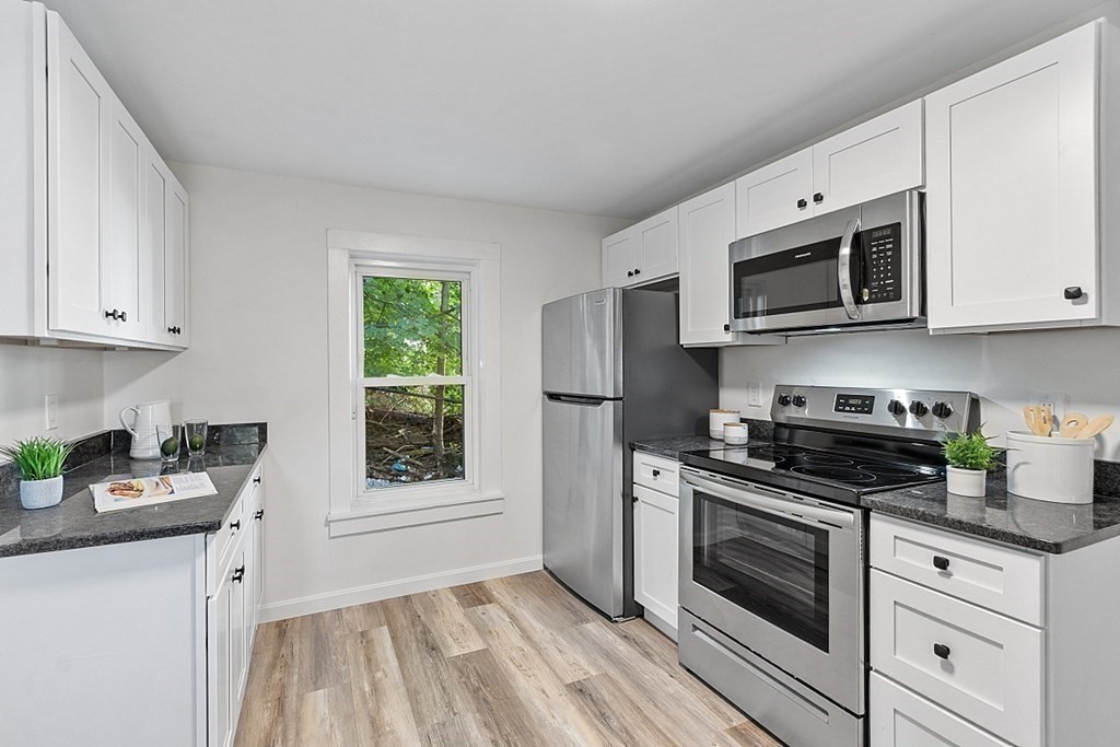 5 Montreal Street Worcester, MA 01604 - Photo 16 of 29 a kitchen with stainless steel appliances granite countertop white cabinets and a stove top oven