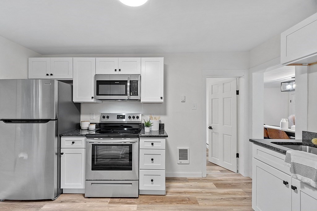 5 Montreal Street Worcester, MA 01604 - Photo 17 of 29 a kitchen with white cabinets and stainless steel appliances