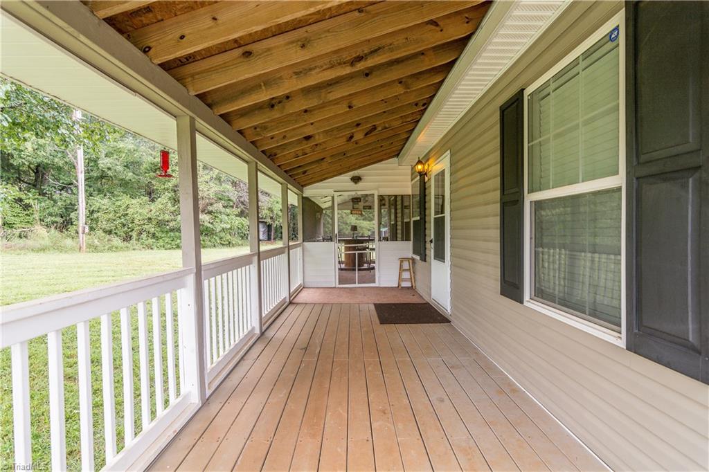 1049 Hickory Fork Road Walnut Cove, NC 27052 - Photo 2 of 24 Looking for a place to gather with family and friends or relax after work or weekends. This front porch overlooking the yard will be the place.