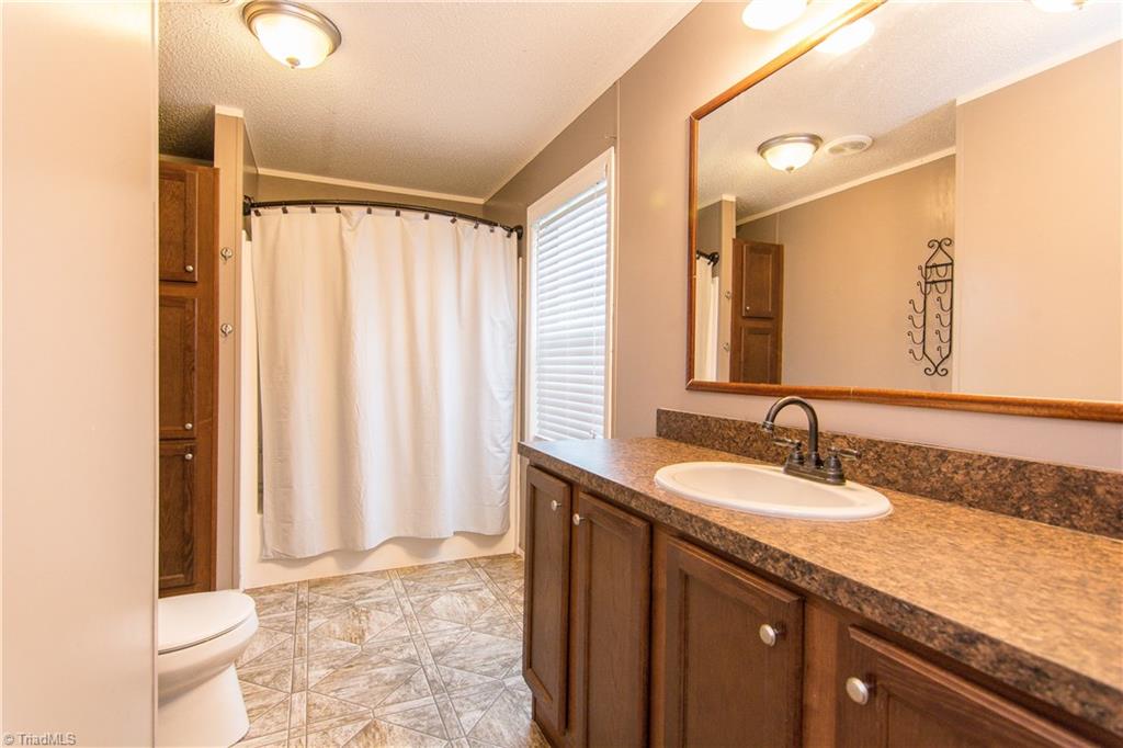 1049 Hickory Fork Road Walnut Cove, NC 27052 - Photo 13 of 24 The master bath is a great size with a tub/shower combo, large counter space, and vinyl flooring.