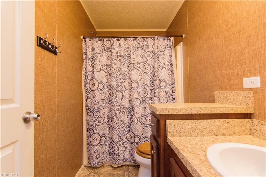1049 Hickory Fork Road Walnut Cove, NC 27052 - Photo 17 of 24 The second bath has a tub and shower combo with vinyl flooring.